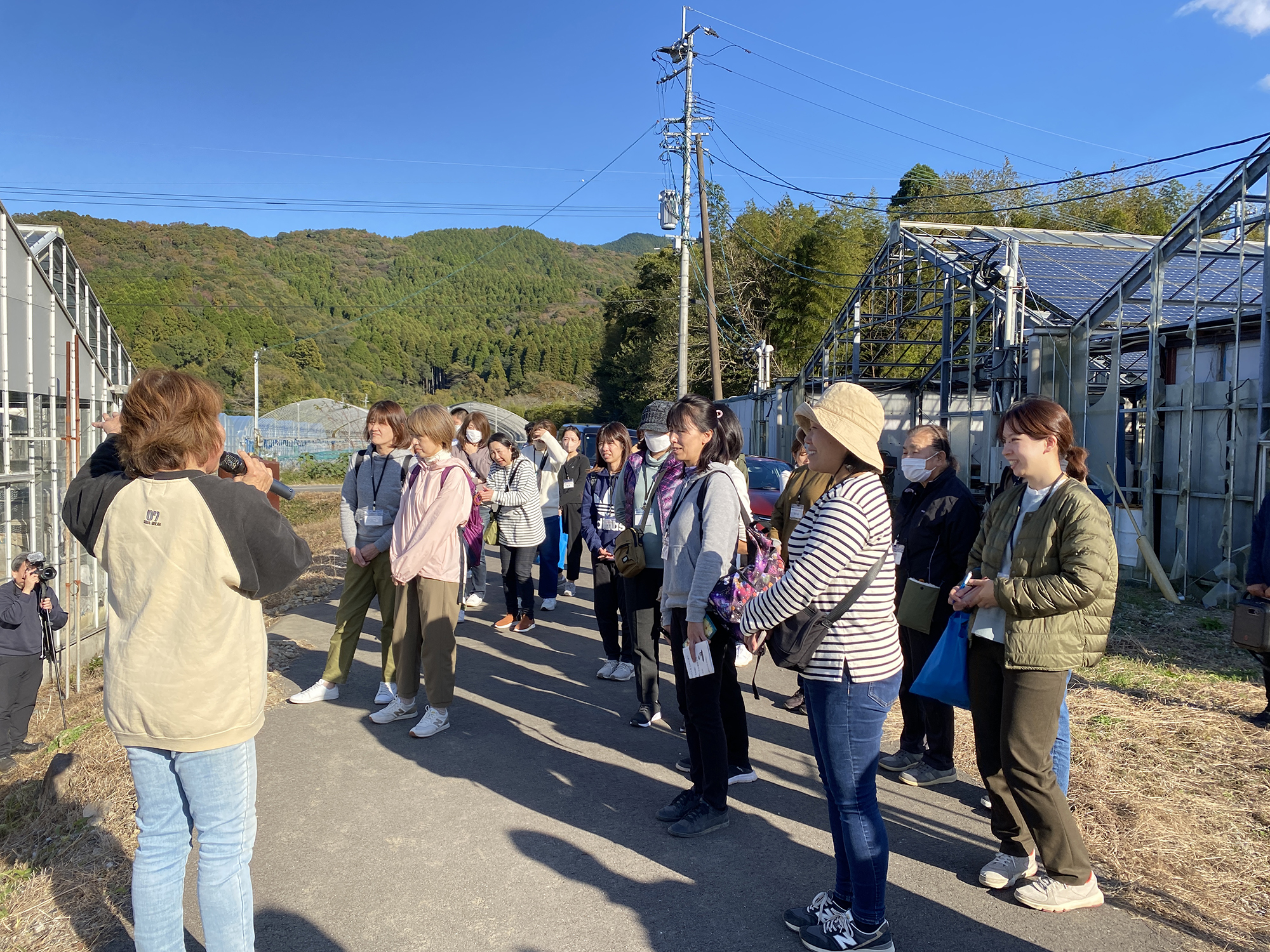 ハウスの外で眞由美さんの話を聞く参加者